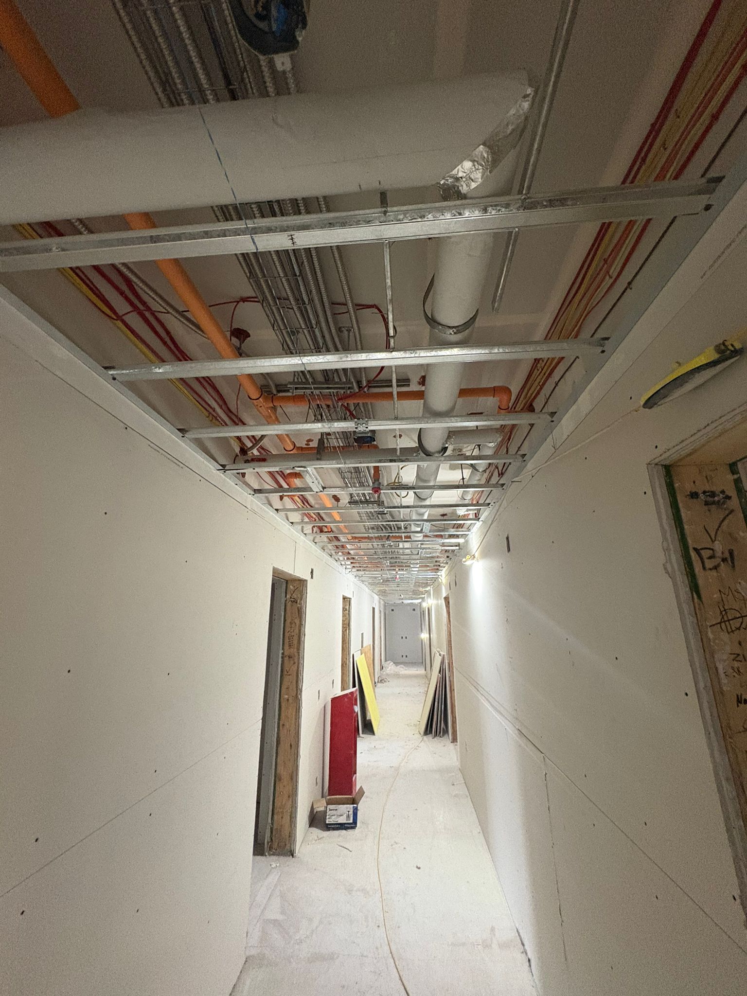 Drywall boarding installation showing hallway with ceiling framework